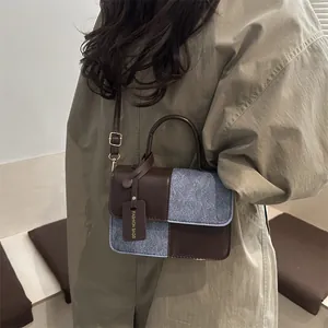 Brown and grey patchwork crossbody bag with adjustable strap and fashion label charm