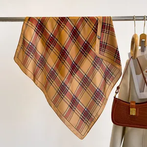 Detail of a brown silk square scarf with a classic check pattern on a garment rack