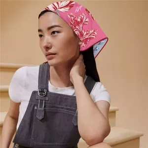 Detailed view of pink floral tulip neck scarf styled as a headband on a female model