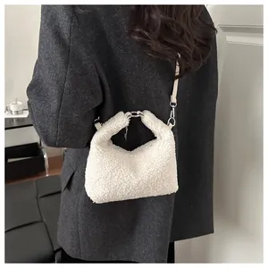 Vue détaillée du sac seau blanc en laine avec chaîne argentée porté par un mannequin