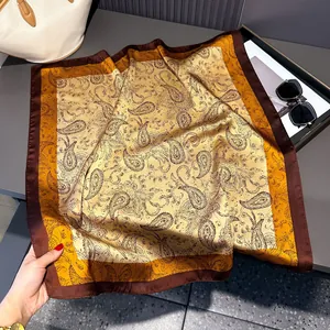 Detailed view of square silk scarf with vintage paisley print in brown and yellow tones