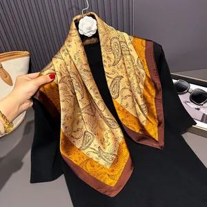 Detail of 70cm silk-like square scarf featuring brown and orange Paisley floral patterns