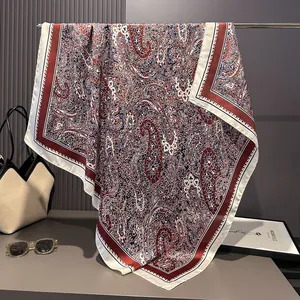 Detail of red and blue paisley silk scarf with elegant drape on a premium metal hanger