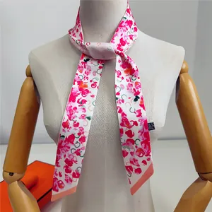 Twilly de 120cm en soie à imprimé floral rose et orange noué sur un mannequin de cou