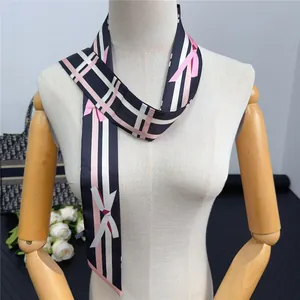 Pink bow silk scarf with check pattern shown on a luxury handbag with white roses