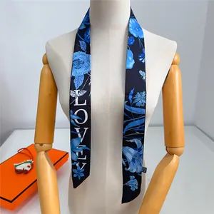 Dettaglio di un foulard in seta nera da 120cm con fiori blu, libellule e scritta LOVE
