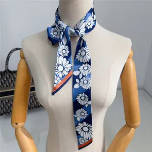 Detalle de una cinta de seda azul marino con estampado floral anudada en un maniquí