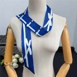 Blue and white geometric silk twilly scarf styled on a wooden mannequin neck