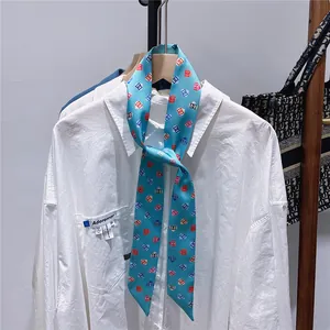 Nahaufnahme eines blauen Seidenschals mit geometrischen Drucken auf einem weißen Hemdkragen