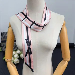Pink geometric pattern silk scarf styled as an elegant necktie on a female mannequin