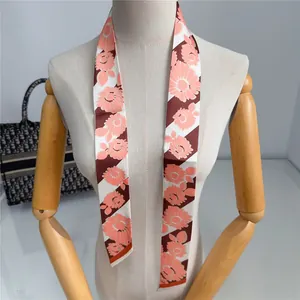 Detalle de pañuelo de seda con flores y rayas utilizado para decorar el asa de un bolso