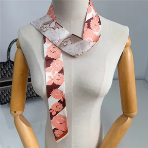 Primer plano detallado de un pañuelo largo de flores atado al cuello como accesorio de moda