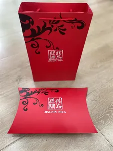 Red silk gift box and matching paper bag with elegant black vine patterns and logo