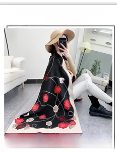 Détail d'un châle en imitation cachemire avec roses rouges, chaînes et bord à franges