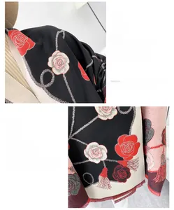 Détail du motif camélia rouge et blanc et des franges sur cette écharpe pashmina