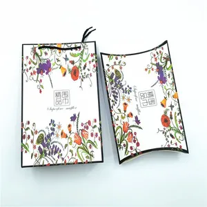 Macro view of red gift box and matching carrier bag with floral tulip patterns