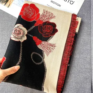 Détail de l'écharpe camélia d'hiver avec jacquard de rose rouge et bordures à franges