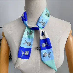 Detail van een zijdezachte smalle sjaal met ananasprint en geometrische kleurpatronen