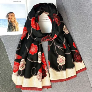 Détail du motif de roses et des franges courtes sur une écharpe épaisse en cachemire