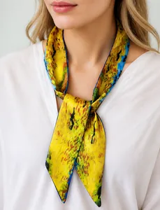 Close-up of a yellow artistic print skinny scarf styled on a white V-neck shirt