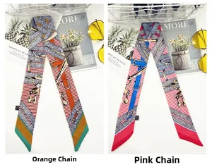Dettaglio di foulard sottili in seta con motivi a catena nei toni arancio e rosa