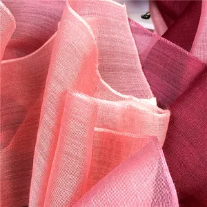 Dettaglio di sciarpa in seta e lana sfumata rosa e bordeaux con trama a rete traspirante