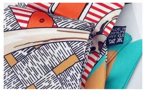 Macro detail of silk-like twilly scarf showing fine diagonal weave and vibrant prints