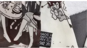 Detail of printed silk scarf showing twill texture, anime pattern, and care label