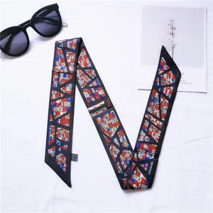 Detail of a narrow silk scarf with geometric house patterns and smooth satin texture