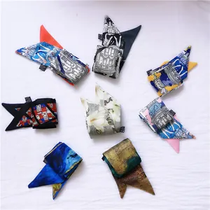 Detail of colorful printed twilly silk scarves arranged in a radial circle on white fabric