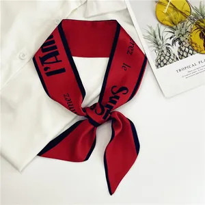 Elegante pañuelo de satén rojo con letras vintage sobre camisa blanca para el verano