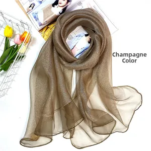 Detail of champagne silk wool scarf with shimmering texture and wavy hemmed edges