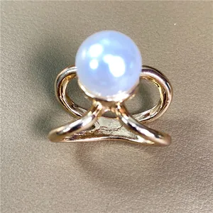 Macro di un elegante anello ferma-foulard dorato con una grande perla bianca lucente