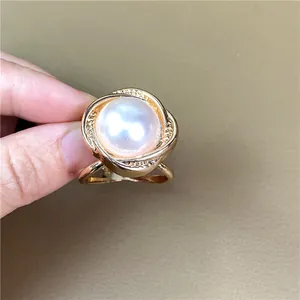 Vista dettagliata di un anello da sciarpa a spirale dorata con grande perla bianca