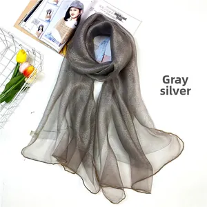 Detail of grey silver scarf with shimmering metallic finish and gold stitched edges
