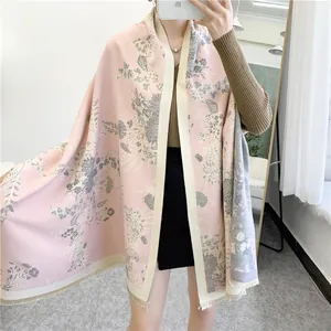 Detail of soft winter scarf showing elegant floral pattern and delicate beige tassel fringe