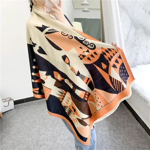 Detailed view of poker Queen print scarf with tassels in orange and beige tones