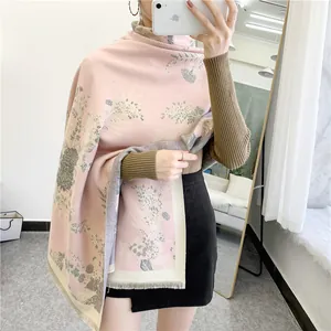 Detail of pink floral cashmere feel scarf featuring delicate tassels and soft knit texture