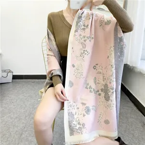 Close-up of elegant floral cashmere-like scarf showing soft texture and fine tassels