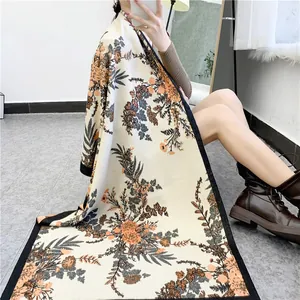 Close-up of floral cashmere feel shawl with orange flowers and elegant black borders