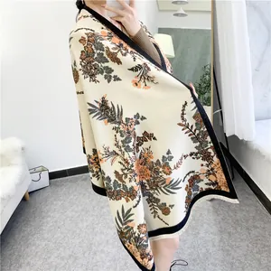 Detail of floral cashmere-like winter shawl with black borders and white tassels