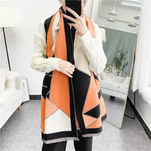 Close-up of geometric color block scarf with soft tassel details in autumn colors