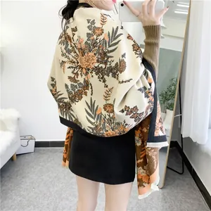 Detailed macro view of cream floral cashmere scarf with elegant tassels and vintage pattern