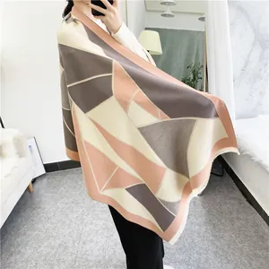 Detail of geometric thick cashmere-like scarf with pastel tassels in home setting