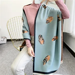 Close-up of soft light blue pashmina shawl with realistic feather print and white fringes