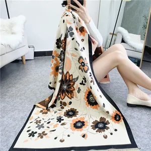 Détail d'une écharpe d'hiver bohème avec motifs floraux tricotés sur un canapé blanc