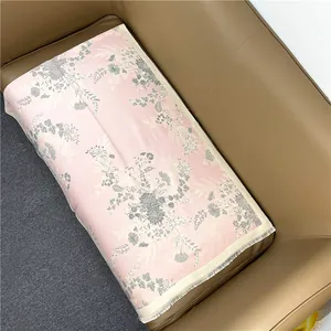 Close-up of pink winter shawl featuring grey floral patterns and elegant white fringe