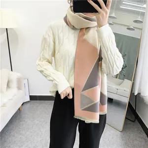 Detail of color-block scarf with soft geometric patterns and delicate fringe trim