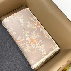 Close-up of floral cashmere feel scarf with orange patterns and tassel edges