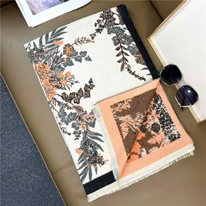 Close-up of elegant floral cashmere scarf with thick tassels and reversible pattern